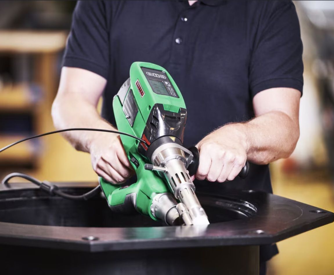 Technician using extrusion welder on a tank rim
