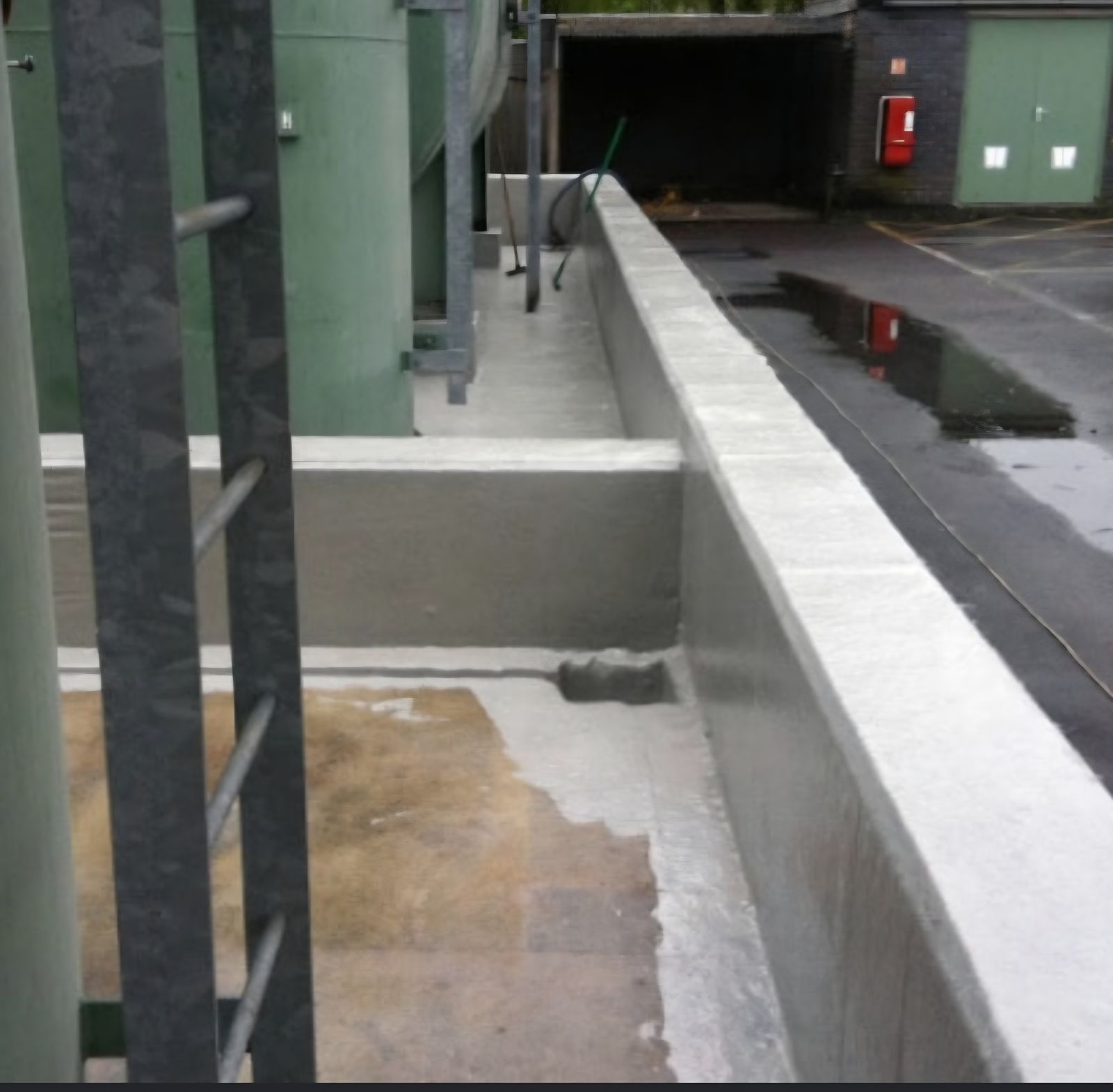 Coated concrete bund wall walkway alongside a facility