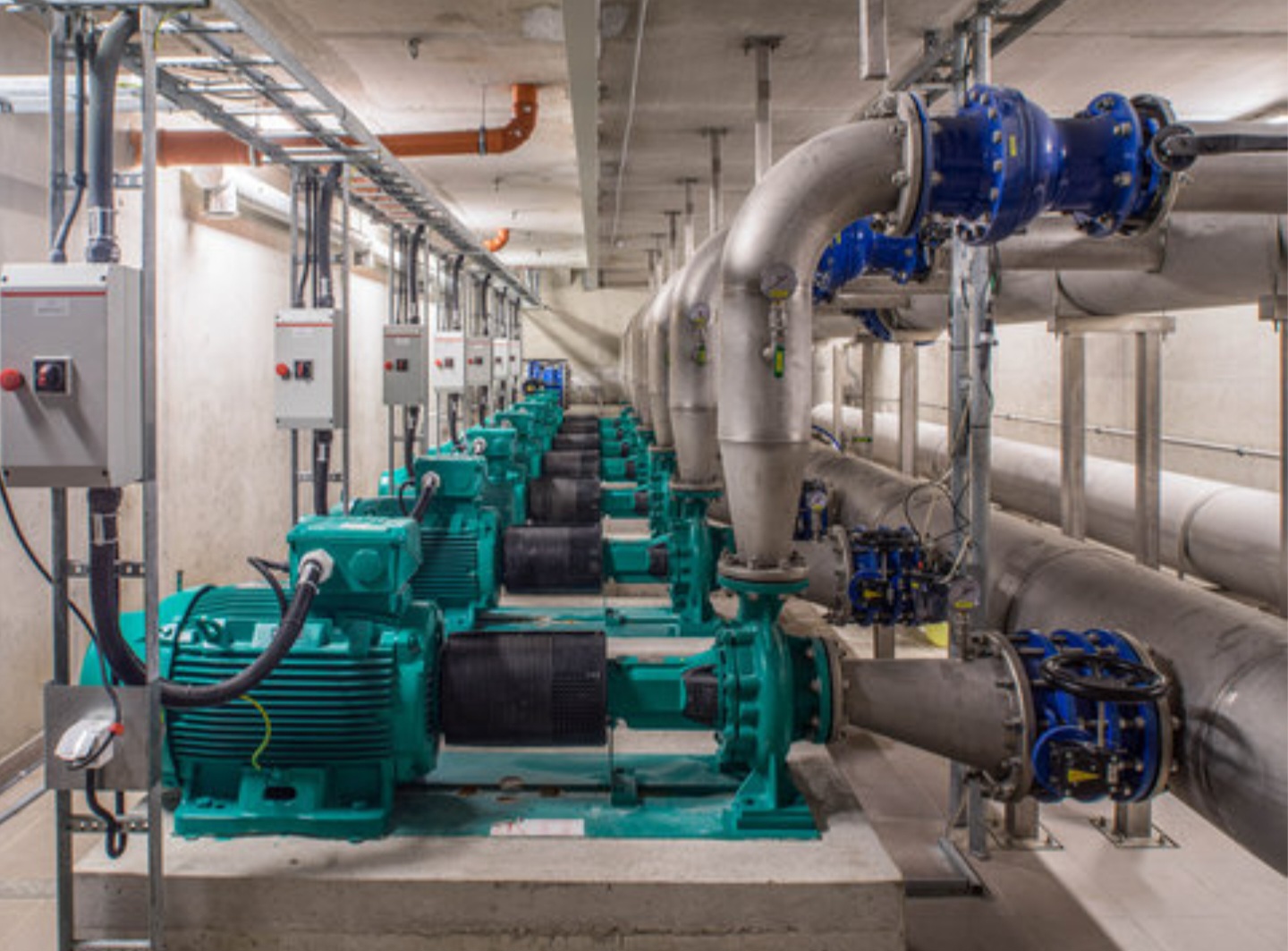 Twin motor and pump units on-site at an industrial plant with green non-metallic pipework