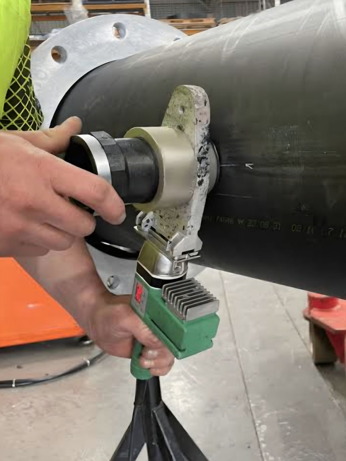Technician performing socket fusion welding on HDPE pipe with flange fitting